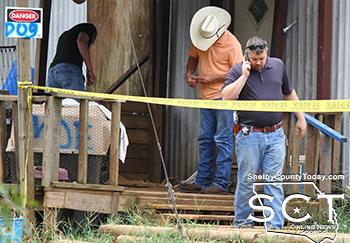Shelby County Sheriff's Investigator Chad Brown (foreground) Shelby County Sheriff Willis Blackwell (hat) and Shelby County Investigator DJ Dickerson (background) are seen investigating the scene at the front of the house Saturday.