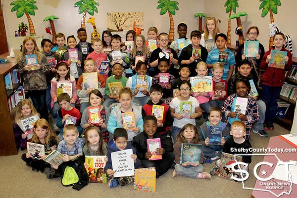 S.W. Carter Elementary students proudly display their new books which were donated by JML Management, Inc.