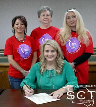 Judge Allison Harbison (seated) signs the proclamation with (from left, standing) Stacy O'Rear, Shirley Brittain, and Kelli Talbert