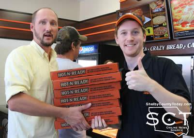 Joshua Moody receives pizza from Rodney Norman of Little Caesars.
