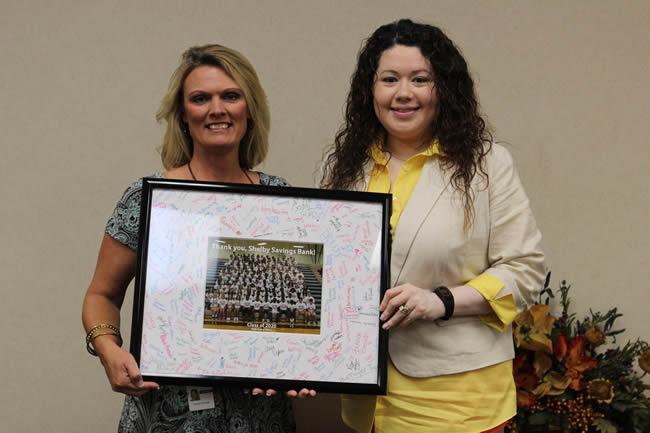 Shelby Savings Bank Marketing Director Lorei Choate and Loan Assistant Anabel Emmons receive a gift from the freshmen class.