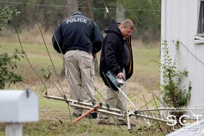 Center Police Officers searched the scene around the residence where the incident allegedly occurred, in search of evidence. Detective Stephen Stroud is seen scanning the area with a metal detector, while Detective Bobby Walker also searched the grounds.