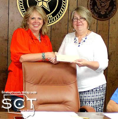 Robin Connell, representing Shelby County Children's Advocacy Center, is seen receiving a check on behalf of the organization from Debra Pate Smith, Timpson Mayor on April 18, 2017. The check was for $551.03 and is a result of the collection of the Child Safety Fee by Shelby County.