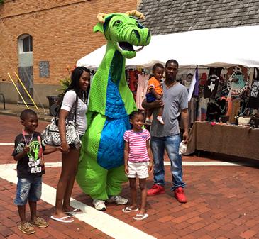 A family poses with the SFA School of Theatre’s trademark dragon character Schlaftnicht at the Texas Blueberry Festival in downtown Nacogdoches. A variety of costumed fairy tale characters will be at this year’s festival on June 10.
