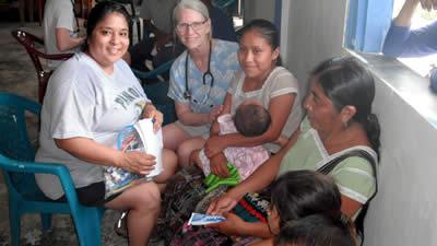 Avila and Cordell with a family in Belize awaiting a check up.