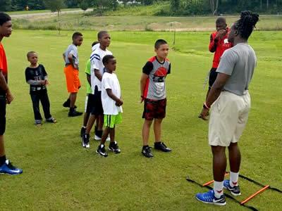 Former Center Roughrider Jeremy Small is seen giving tips to camp participants.