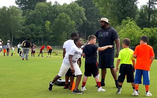 Desmond Hillard is seen on the field instructing campers during the Preston Football Camp.