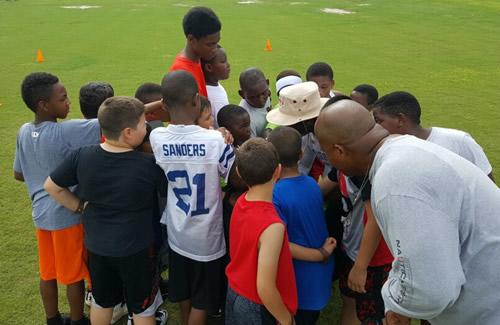 Dwight Preston and John Preston in a huddle with campers.