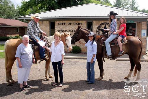 Gary City Secretary Pam Woodfin welcomed the Timpson Frontier Days envoy. Pictured are (from left): Marilyn Corder, Timpson Area Chamber of Commerce Representative; Danny Dixon on Jalapeño "Pepper" the horse; Pam Woodfin, City Secretary; Rose Dixon; and Sarah Dixon and Delayna Higginbotham on "Floyd" the horse.
