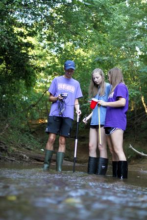  (pictured, from left): Nacogdoches High School seniors Brandon Smith, Marin Beal and Miranda Allbee check the turbidity, take the temperature and measure the depth of the water at Lanana Creek for their Stephen F. Austin State University STEM Academy research project. During their fourth year in the academy, students practice experimental design by conducting their own research.
