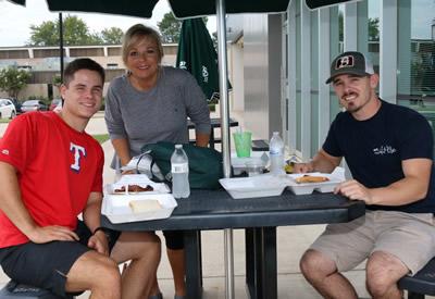 Kade, Pam and Mitch Clemens of Gilmer enjoy lunch provided by Still Waters Cowboy Church. Kade is a third-baseman for the Panola Ponies.