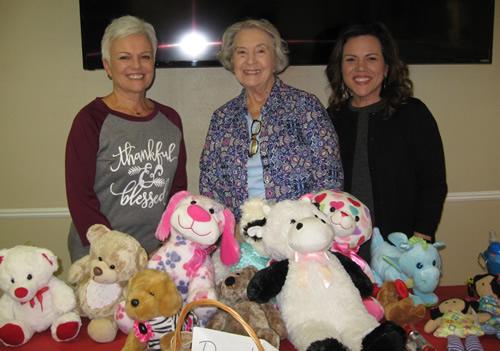 Administrative Assistant, Valerie Warren; program Chairman Linda Anderson; and Executive Director Denise Merriman shown with toys collected by members of the Golden Harvest Ministries Club for the Advocacy Center.