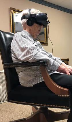 An elder views the images using virtual reality goggles.