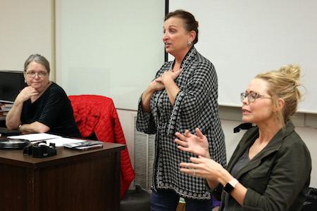 Instructor Betty Gruber, left, listens as Anne Stacy-Robbins explains the benefits of Music and Memory, while Lindsey Hines, with Interpreter Training & Consulting Services, provides interpretation for the deaf.