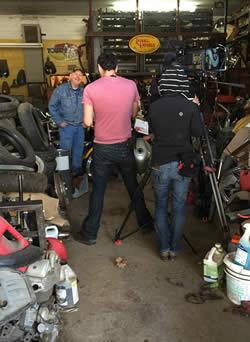 Dennis Leggett (background) in his shop with members of the American Pickers film crew.