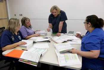 Professor Lynn Davis works with students (from left) Ronna Phillips of Gary, Amber Akin of Henderson, and Chelsey Smith of DeBerry.