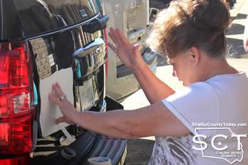 Beverly Slatter installing wording on SCSO vehicles.
