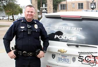Officer John Welch stands beside the "In God We Trust" on his patrol unit.