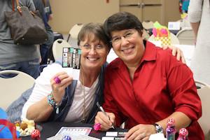 Guests, Terri King and Cheri Lambert, show off their raffle tickets for a chance at the Louis Vuitton handbag. 