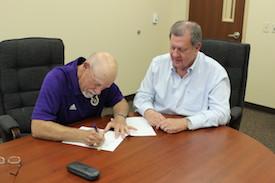 School Board President, James Greer signs the deed beside David Chadwick, Mayor of Center, Texas.